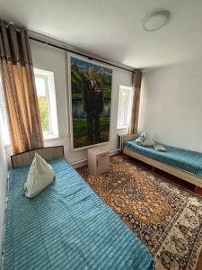 科奇科尔Nomad Guest House的一间设有两张床的客房,墙上挂着一幅画