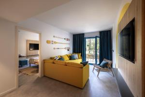 克尔克Krk Sunny Hotel的一间带黄色沙发的客厅和一间卧室