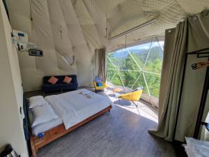 安布罗劳里Glamping Georgia Krikhi的一间卧室设有一张床和一个大窗户