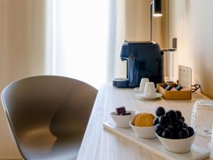 法蒂玛Mercure Fátima的一张桌子,里面装有水果碗,还有一个咖啡壶