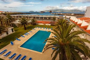 马达莱纳卡拉维拉斯酒店的享有带椅子和棕榈树的度假村游泳池的顶部景致