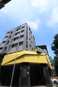 台中市逢甲25行館Fengjia 25 Hotel的一座高大的建筑,上面有黄色和灰色的顶部