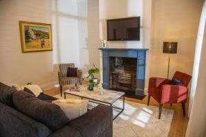 悉尼Balmain Sandstone Cottage的带沙发和壁炉的客厅