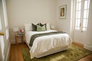 悉尼Balmain Sandstone Cottage的白色卧室配有白色床和绿色枕头