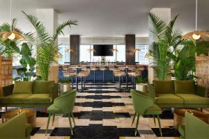 迈阿密W迈阿密酒店的酒店大堂设有绿色椅子和酒吧