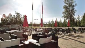 皮特奥皮特奥高尔夫酒店的一个带桌椅和红色遮阳伞的庭院