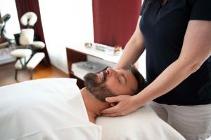 玛丽亚温泉Spa & Wellness Hotel Olympia Marienbad的把男人的头发剪在床上的女人