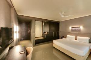 贝尔高姆Hotel Sankam Residency的卧室配有一张白色的大床和一张桌子