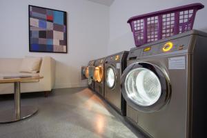巴塞罗那巴塞罗那辉盛凯贝丽酒店式服务公寓的洗衣房里的一排洗衣机