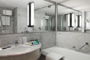 鲁瓦西昂法兰西Sheraton Paris Charles de Gaulle Airport Hotel的带浴缸、水槽和镜子的浴室