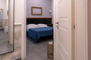 那不勒斯Hotel San Michele的一间卧室配有一张带蓝色床罩的床