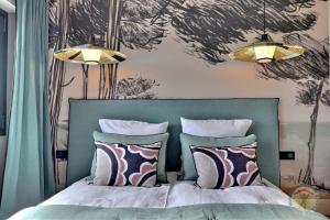 圣吕奈尔Les dunes的一间卧室配有一张带绿色床头板和枕头的床。