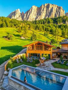 科尔福索Kolfuschgerhof Mountain Resort的山前带游泳池的房子