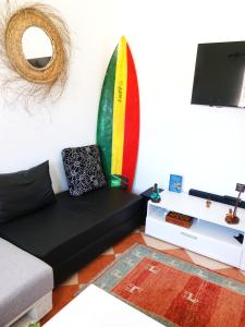 依索安Olas Surf House的客厅配有沙发和冲浪板。