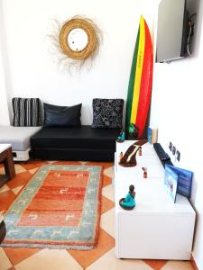 依索安Olas Surf House的客厅配有黑色沙发和冲浪板