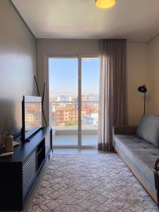 圣玛丽亚Morcelli Mobiliados - Uniqo Smart Living的带沙发和大窗户的客厅