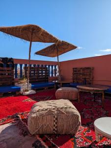 依索安Olas Surf House的配有桌椅和遮阳伞的房间