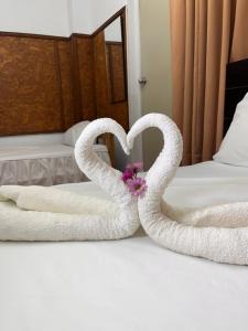 普卡尔帕埃尔啡旅馆的两条毛巾,形状像天鹅,坐在床上