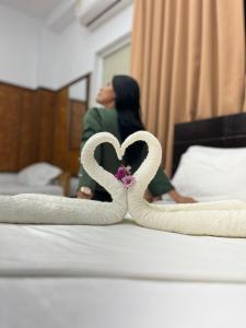 普卡尔帕埃尔啡旅馆的坐在床上的女人,身着两条心形的毛巾