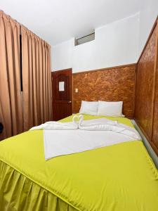 普卡尔帕埃尔啡旅馆的一间卧室配有一张带黄色床单的大床