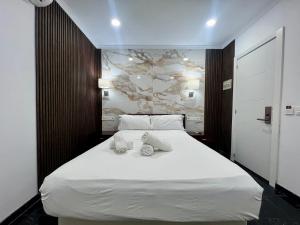 马贝拉Boutique Princesa的卧室配有带毛巾的大型白色床