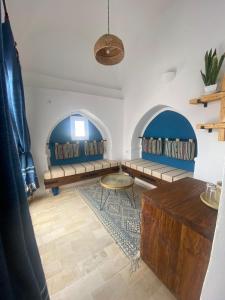 米多恩Hôtel Djerba Authentique - Au centre de Midoun的客厅设有2张长椅和桌子