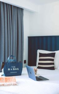 卡斯Aphrodite Hotel Kaş的睡在床上的蓝色袋子,带笔记本电脑