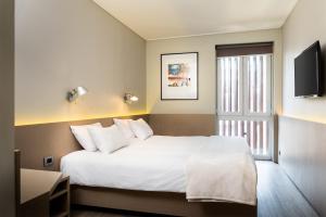 圣地亚哥Novapark的卧室设有一张白色大床和一扇窗户。