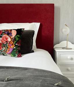 勒法韦La Maison de Louisette的一张带红色床头板和枕头的床