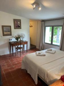 圣萨蒂南艾普特乐多迈纳圣让酒店的一间卧室配有一张床、一张桌子和一个窗户。