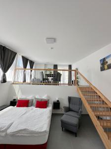 格拉茨Grazora Living Apartments的一间卧室配有一张床、一把椅子和楼梯