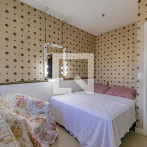 里约热内卢Apartamento Neolink Barra da Tijuca的一间卧室配有一张床、镜子和椅子