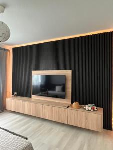 不来梅港Seli Apartment的一间客厅,客厅的电视挂在黑墙上