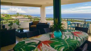 帕皮提Kaili Ocean view luxury 2BR AC throughout Fiber Wifi & Pool的阳台配有桌子,享有海景。