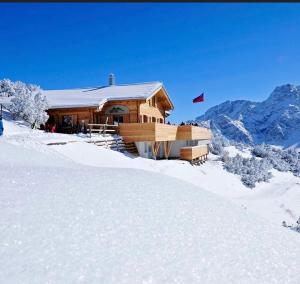 马尔邦SAREIS Bergrestaurant的雪地小木屋,带旗帜