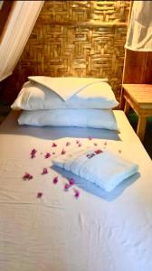 道伊斯Bohol Island Homestay的一张床上铺有粉红色玫瑰花瓣