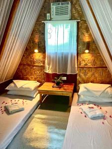 道伊斯Bohol Island Homestay的配有2张床的带窗户和桌子的客房