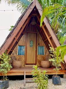 道伊斯Bohol Island Homestay的茅草屋顶小屋,设有木门