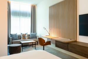 阿姆斯特丹阿姆斯特丹竞技场阿特拉斯公园万怡酒店的酒店客房配有一张床、一张书桌和一张沙发。