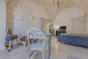 奥斯图尼Masseria Conca D'Oro的卧室配有一张床和一张桌子及椅子