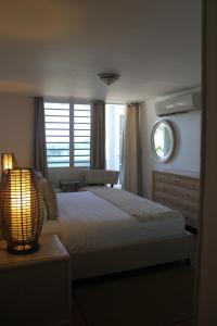 圣胡安德尔马尔旅馆的一间卧室配有一张带灯和窗户的床