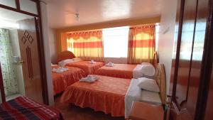 普诺HOSTAL ACUARIUS PUNO的一间卧室配有两张床和镜子