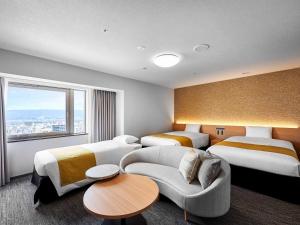 和歌山歌山大和鲁内酒店 的酒店客房,设有两张床和一张沙发