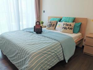 吉隆坡OPUS RESIDENCE KL I HomeBrickz的一间卧室配有一张带蓝色棉被和枕头的床