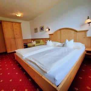 多弗加斯坦加施泰因旅馆的一间卧室配有一张大床和木制床头板