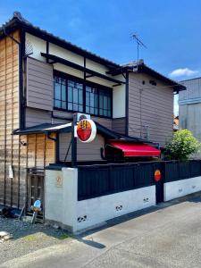 桐生市Okiya Guest House & Tapas Bar的前面有标志的建筑