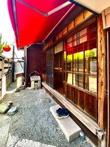 桐生市Okiya Guest House & Tapas Bar的一座红色屋顶和一些窗户的建筑