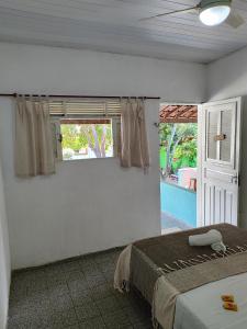 皮帕Pousada Carambola的一间卧室设有一张床和一个窗口