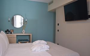 雅典阿瑞图萨酒店的一间卧室配有一张带白色毛巾的床