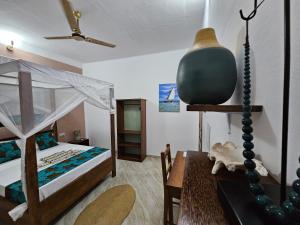 南威Zanzicrown的一间卧室配有一张床和一张桌子及四柱床